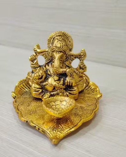 Ganesh Idol Sitting on Pipal Leaf with Diya Gold Plated Metal Statue